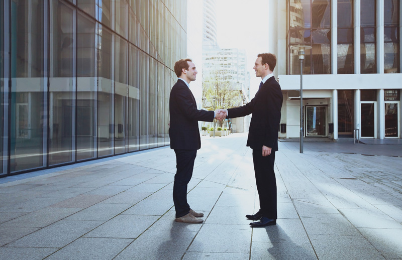 Two real estate management professionals shaking hands