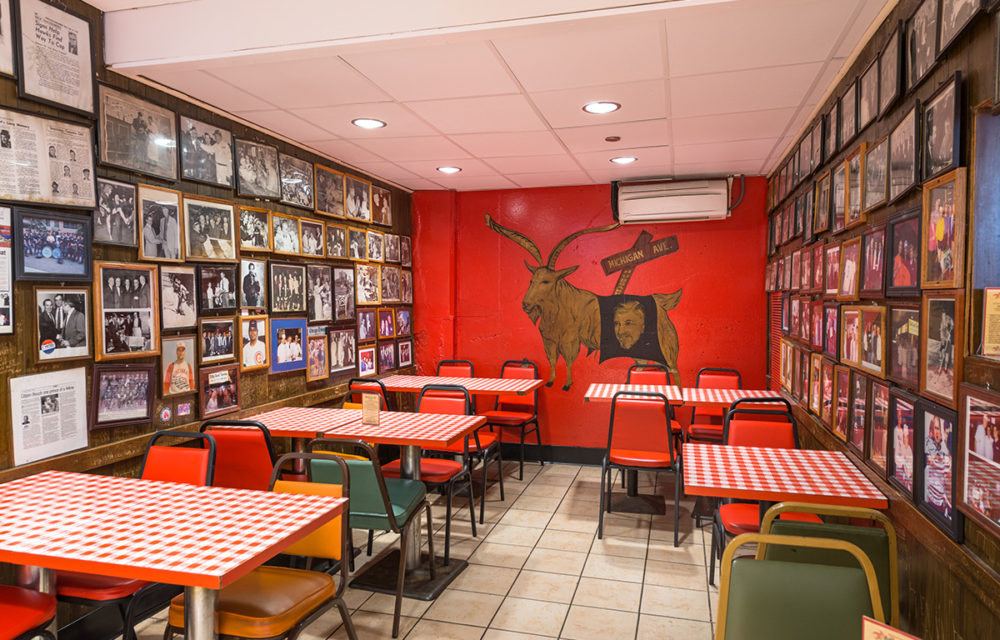 Seating area at The Billy Goat Tavern with goat mural on the rear wall